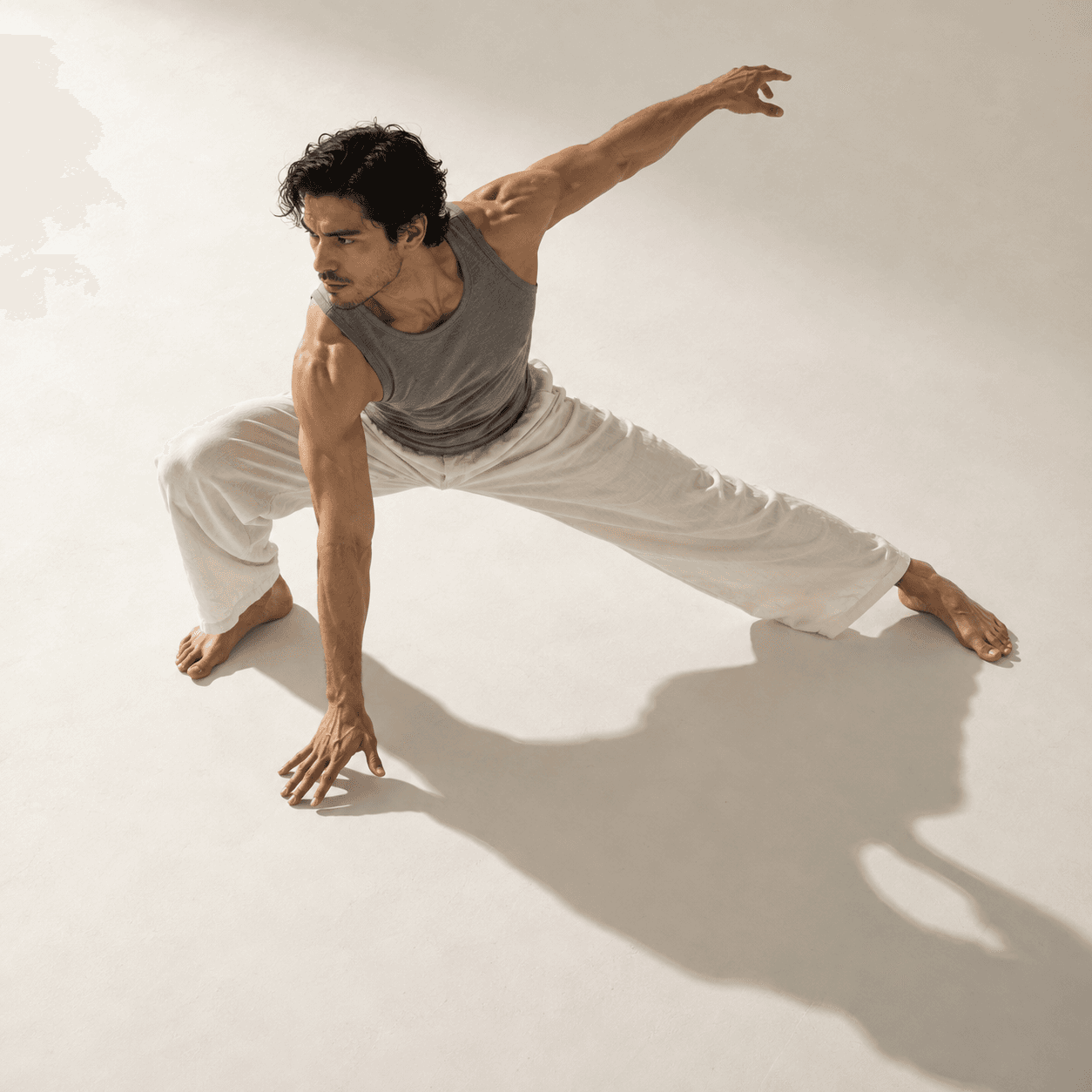 Hombre en pose dinámica de movimiento en estudio minimalista.